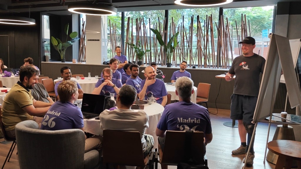 WunderGraph teammates in a workshop during Madrid Work Week, leaning in as someone presents at a flipchart